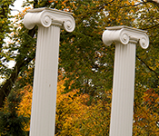 Two Greek columns of UW's Sylvan Grove surrounded by fall foliage and evergreen trees