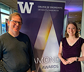 Stefan Savage and Justine Sherry stand in front of a large sign with UW College of Engineering logo and Diamond Awards graphic