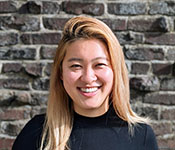 Headshot of Miranda Wei wearing a black sweater against a brick background