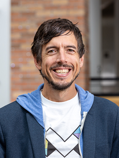 Portrait of Jon Froehlich wearing a t-shirt branded with an M logo for the Makeability Lab