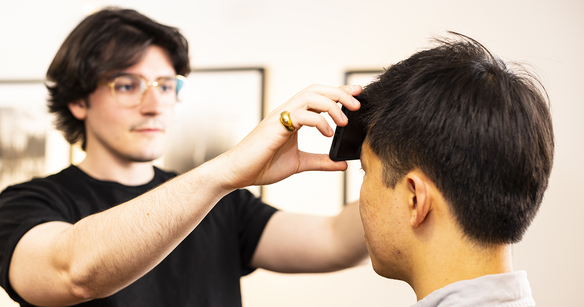 Joe Breda holds a smartphone against a patient's head to show how the FeverPhone app works.