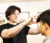 Joe Breda holds a smartphone against a patient's head to show how the FeverPhone app works.