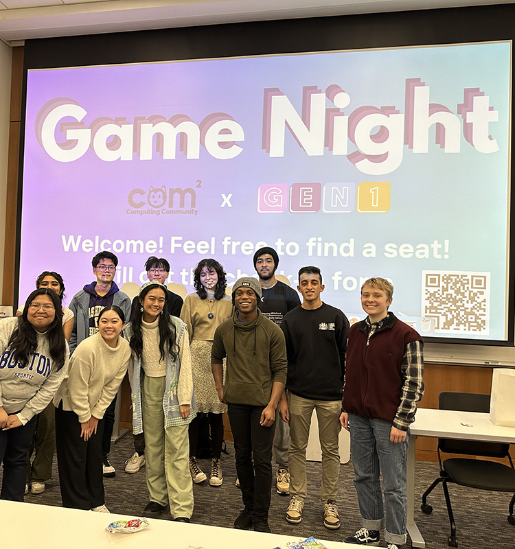 Members of GEN1 and Computing Community stand in front of a screen describing their joint game night. 