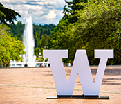 The University of Washington "W" stands in the forefront withe Drumheller Fountain in the background.