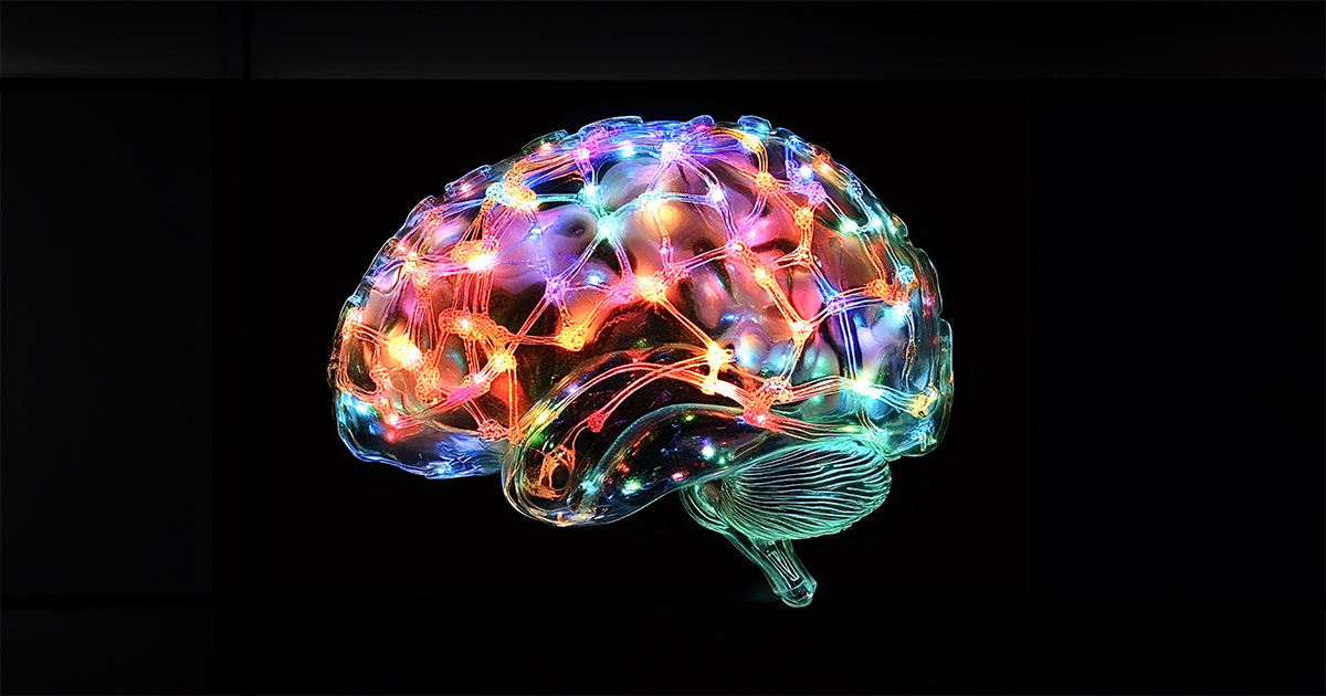 Glass brain model showing illuminated neural network on black background.