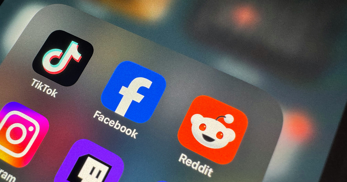 A close-up image of various social media icons including Reddit, Facebook and TikTok on a smart phone.