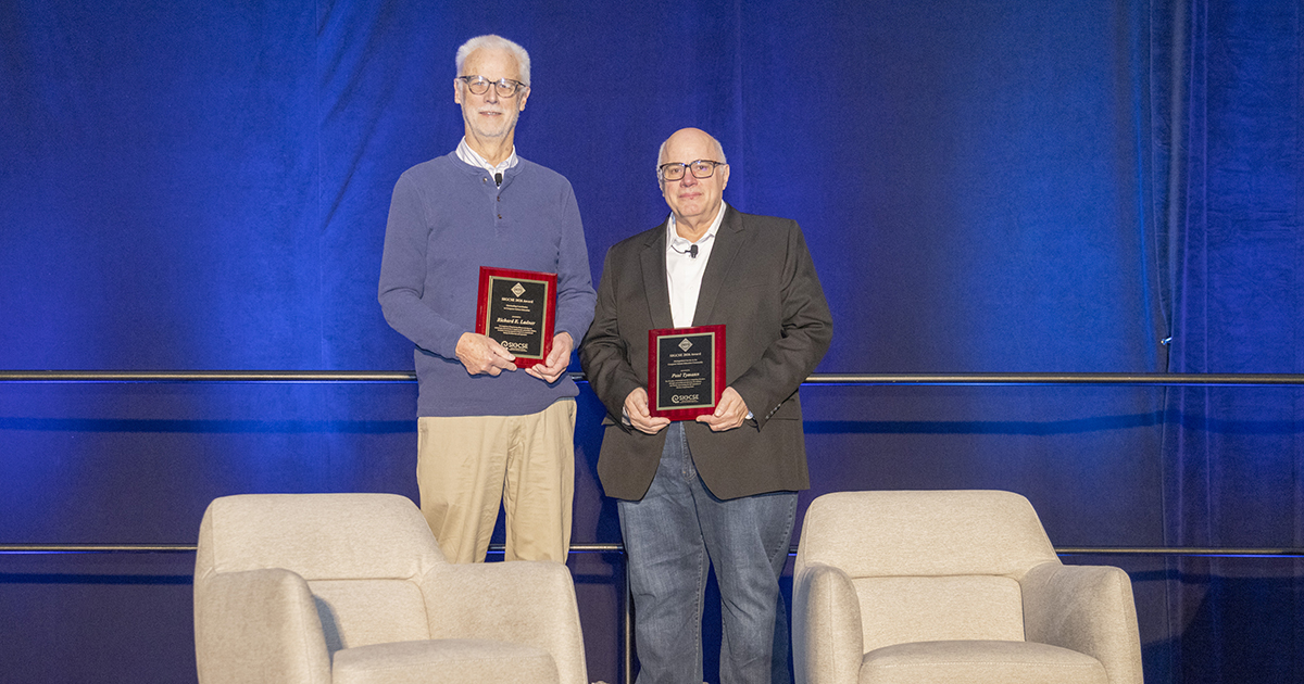 Allen School professor Richard Ladner holds the plaque he received for the SIGCSE Award for Outstanding Contribution to Computer Science Education. Next to him is Paul Tymann holding the plaque he received for the SIGCSE Award for Distinguished Service to the Computer Science Education Community.